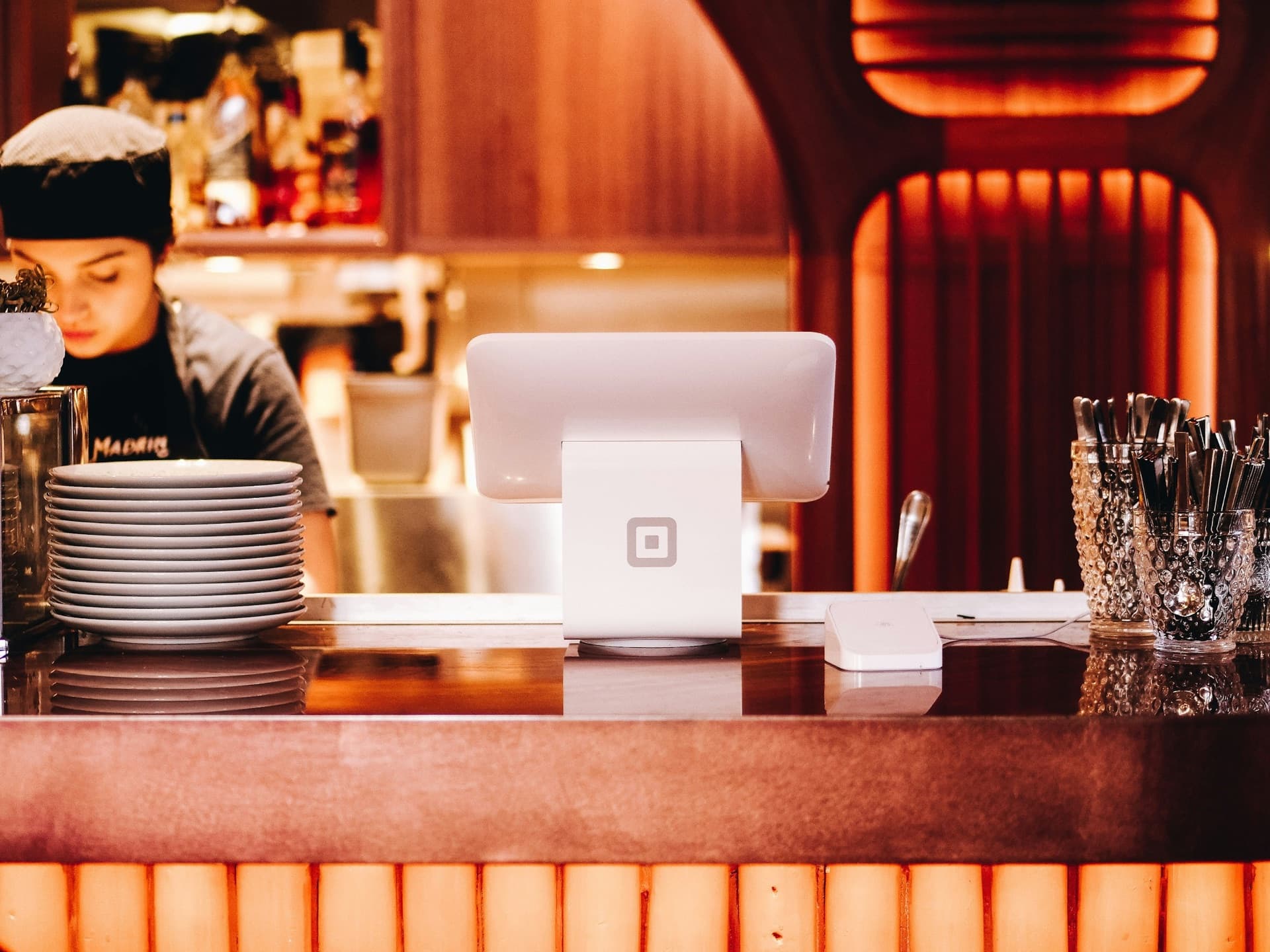 Gastgeberin am Tresen eines Restaurants mit warmem Ambiente, Gastronomie die ihren Google-Auftritt mit dem Sterne-Autopiloten stärkt.