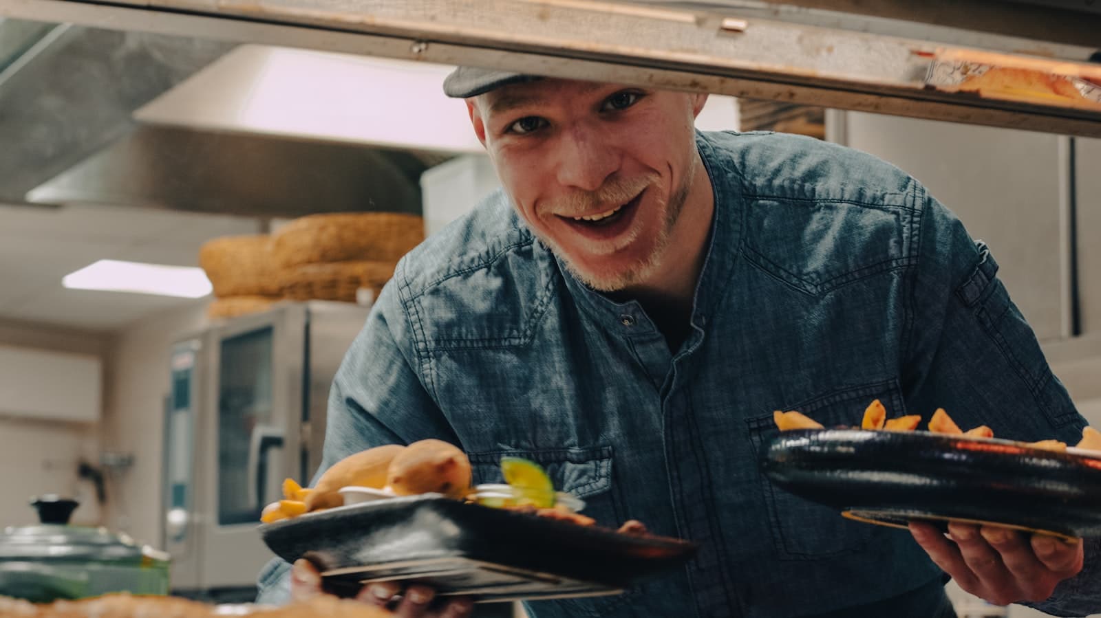 Koch serviert mit Freude ein Gericht — Beispiel für die Art von Restaurants, deren Websites die Tavolo-Demoseiten zeigen.
