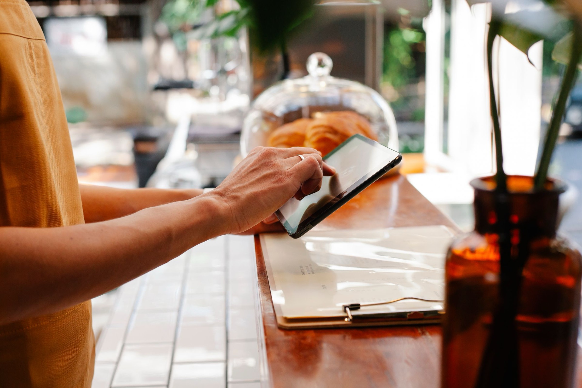 Gastronomin am Tablet im Restaurant rechnet ihre Reservierungskosten durch